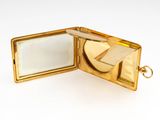 a small gold case with a mirror inside of it