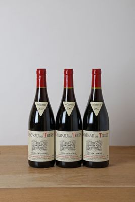 trois bouteilles de vin posées sur une table en bois
