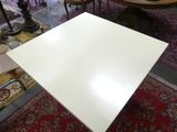 a white table that is sitting on a red rug