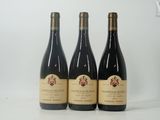 trois bouteilles de vin posées sur une table blanche