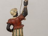 a figurine of a man holding a candelabra on top of a table