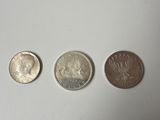 three different types of coins sitting on a white surface