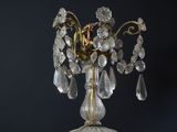 a gold and crystal table lamp on a black table