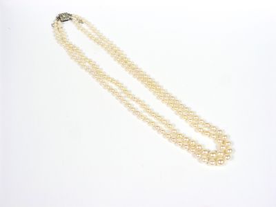 un collier de perles à un rang muni d'un fermoir, sur fond blanc