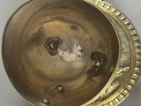 a metal bowl with a handle on a table