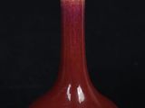 a red vase sitting on top of a black table