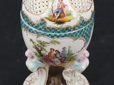 a white and blue decorated egg on a stand