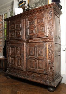 une commode en bois dans une pièce, sur laquelle est posée une horloge