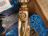 a gold cat statue sitting in a box on the floor