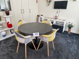une table noire entourée de chaises jaunes dans une pièce