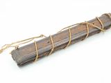 bâton en bois entouré d'une corde, posé sur une surface blanche