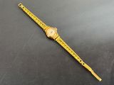 a close up of a watch on a black surface with a ruler