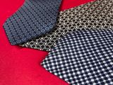 two ties are laying next to each other on a red surface