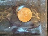 a gold coin sitting in a plastic bag on a table