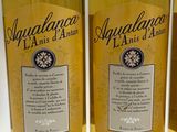three bottles of aquaquana la anis d ' artisan are lined up on a table