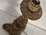 an antique brass candle holder on a white table