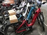 many bikes parked in a parking lot with boxes on them