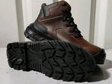 a close up of a pair of brown boots on a white surface