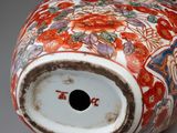 a vase with a lid that has a design of flowers on it