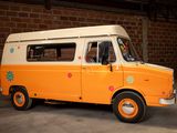an orange and white van parked in front of a brick wall