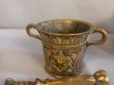 a gold cup and a spoon sitting on a table