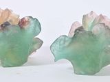 two pieces of glass with leaves on them on a white surface