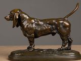bronze statue of a dog standing on a base on a table