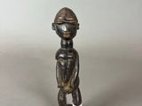une petite figurine en bois coiffée d'un casque