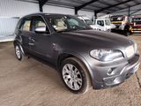 a picture of a silver bmw suv parked in a garage