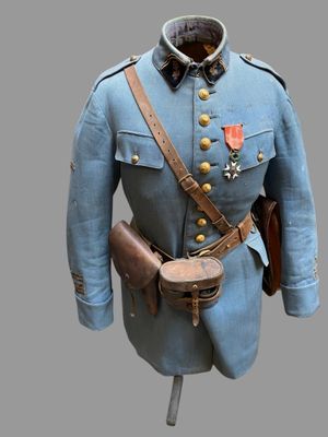 une photo d'un uniforme bleu, avec une ceinture en cuir et un chapeau, posé sur un présentoir pour mannequin