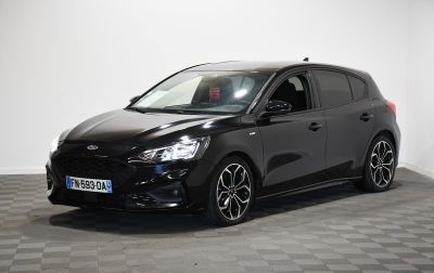 Une Ford Focus noire est garée sur un sol à damier.