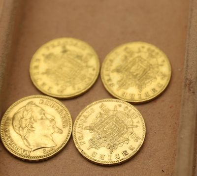 Il y a quatre pièces d'or dans une boîte posée sur une table