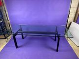 a glass table with black legs and a glass top