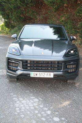 une Porsche Cayenne noire garée sur le bord de la route