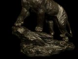 a statue of a bear on a rock on a black background