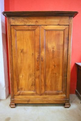 a wooden armoire in the corner of a room