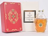 l'image d'un flacon de parfum posé à côté d'une boîte