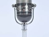 un micro à l'ancienne sur lequel est inscrit « À l'antenne »