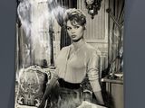 photographie en noir et blanc d'une femme assise à une table avec un livre