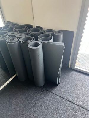 de nombreux rouleaux de tapis de yoga alignés sur le sol