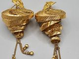 une paire de boucles d'oreilles dorées ornées d'un oiseau