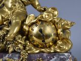 a gold clock sitting on top of a marble base