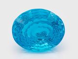 un objet en verre bleu posé sur une surface blanche