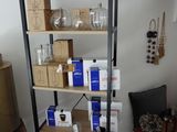 une étagère sur laquelle sont posées des boîtes et des verres, dans un salon