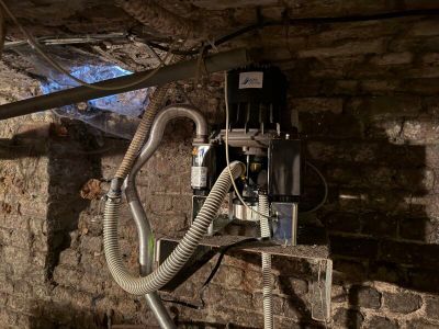 une prise électrique dans un mur en briques, à laquelle sont raccordés de nombreux fils