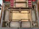 an open suitcase with red cushions inside of it