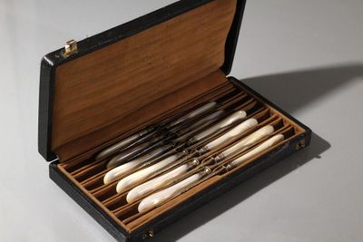 une boîte en bois contenant quatre types de couteaux différents