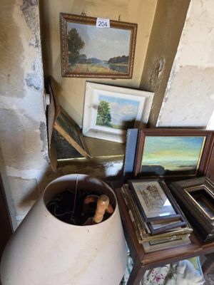 une table sur laquelle se trouvent une lampe, des photos et un vase