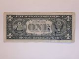 a close up of a one dollar bill on a white surface