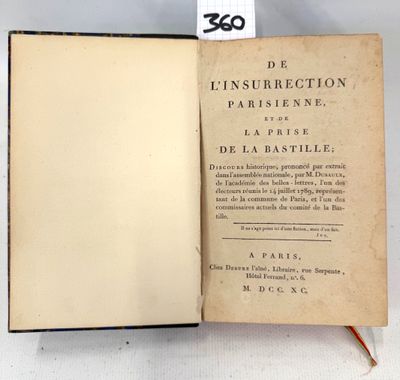 an open book sitting on top of a table next to a tag